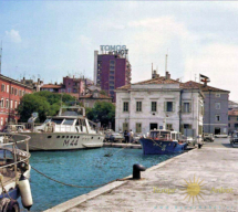Pogled iz pristanišča na nebotičnik z napisom TOMOS na vrhu, v začetku sedemdesetih let. tomos